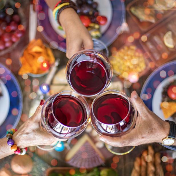 Family dinner for a celebration with red wine and cheers.