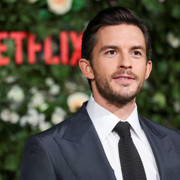 Jonathan Bailey vor einer Wand mit dem Netflix-Logo.