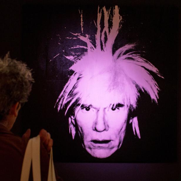 FILE PHOTO: A man examines "Self-Portrait" by Andy Warhol during a media preview at Christie's auction house in New York