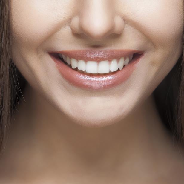 Frau lächelt und zeigt ihre weißen Zähne.