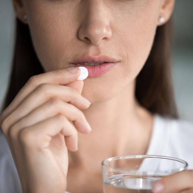 Junge Frau nimmt Tablette ein