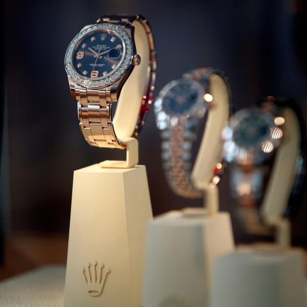 Eine goldene Rolex-Uhr mit Diamanten steht auf einem Sockel.