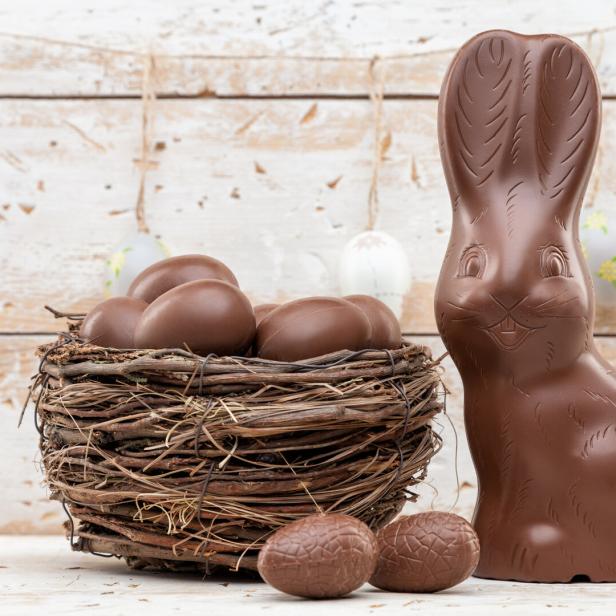 Chocolate Easter bunny, eggs and sweets on rustic background