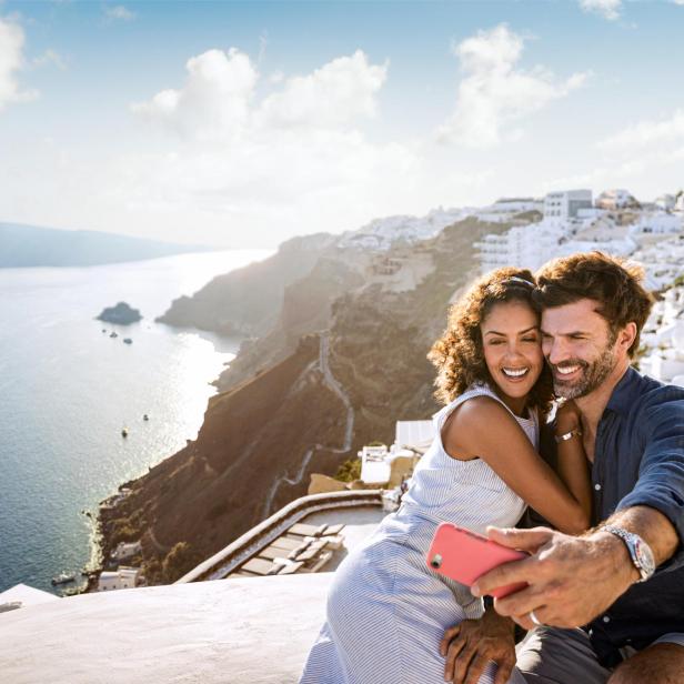 Paar macht Selfie mit dem Panorama von Santorin