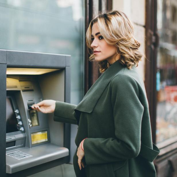 Junge Frau mit Geldautomat - Stock-Fotografie