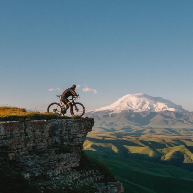 Mann mit Rad auf einem Berg