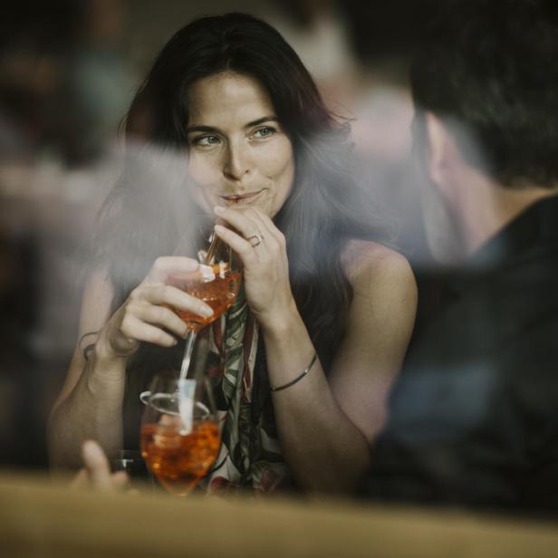 Woman enjoying drink with boyfriend in restaurant - Stock-Fotografie