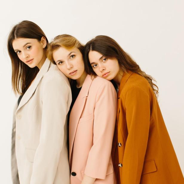Stilvolle junge Frauen in pastellfarbenen Outfits stehen zusammen, Modekonzept - Stockfoto - Stock-Fotografie