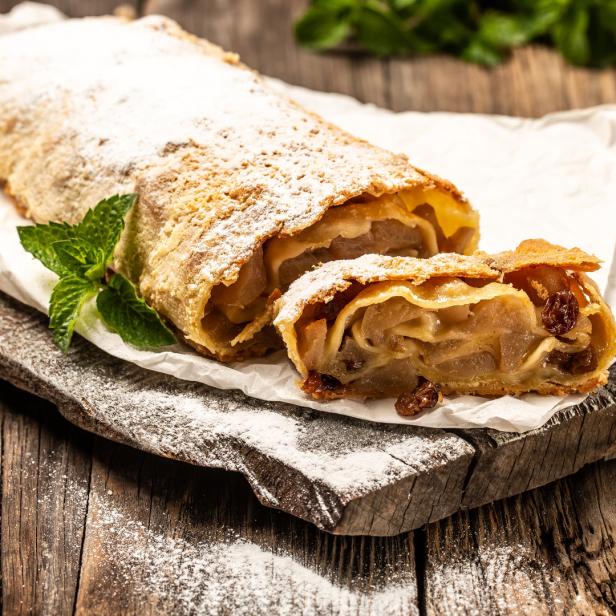 Apfelstrudel auf einem Brett und mit Staubzucker überdeckt