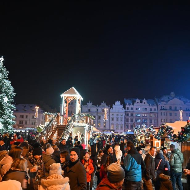 Menschen am Weihnachtsmarkt in Pilsen vor Bürgerhaus Fassaden, Weihnachtsbaum und Riesenrad