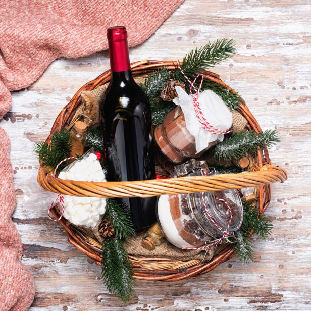 Rotwein und Konfektgläser in einem weihnachtlichen Präsentkorb
