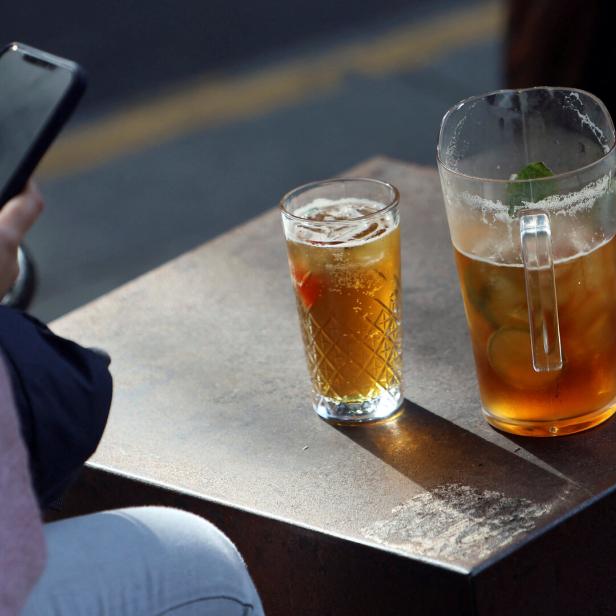 Eine Person sitzt im Wetherspoon und tippt ins Handy, vor ihr zwei Bier.
