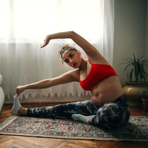 Frau Mutter macht yoga sport daheim