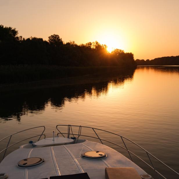 Hausboot auf der Theiß in Ungarn bei Sonnenuntergang, Blick aufs Wasser
