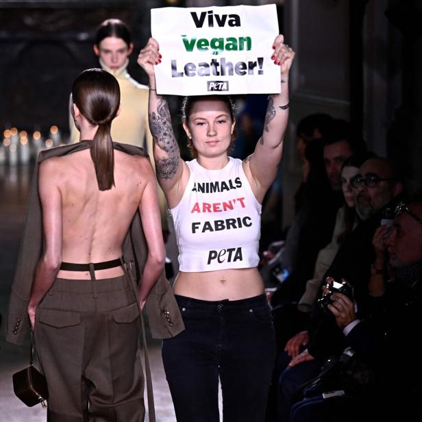 Frau hält PLakat hoch mit Viva Vegan Leather