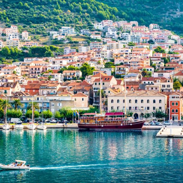 Blick auf die Küstenstadt Supetar in Kroatien mit Booten im Hafen.