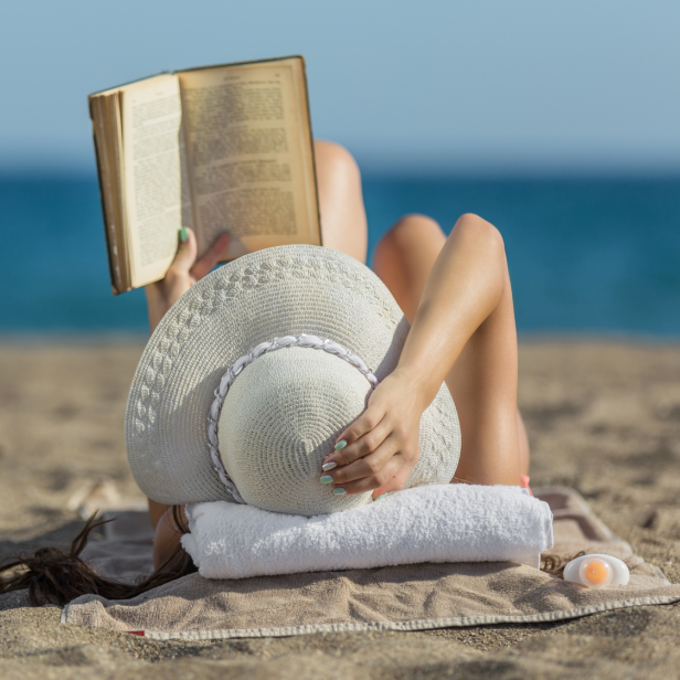 Frau liest am Strand ein Buch 