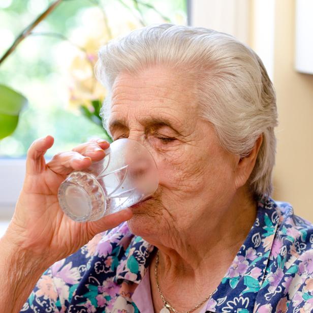 Eine Frau trinkt ein Glas Wasser