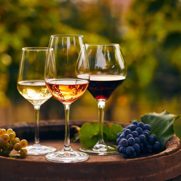 Three glasses of white, ros?É¬© and red wine and an old wooden barrel, with winery still life