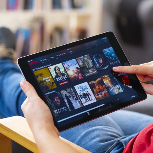 Netflix-User sucht auf einem Tablet nach einem passenden Film