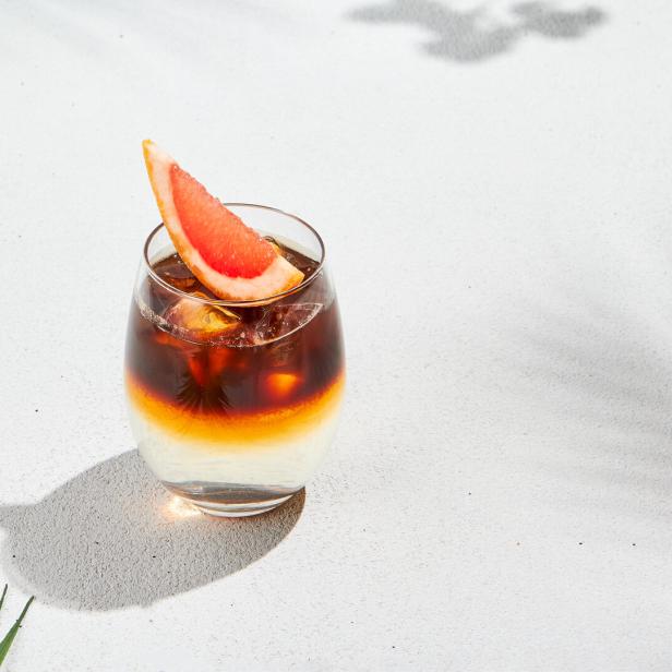 Espresso Tonic mit Orangenscheibe auf weißem Hintergrund