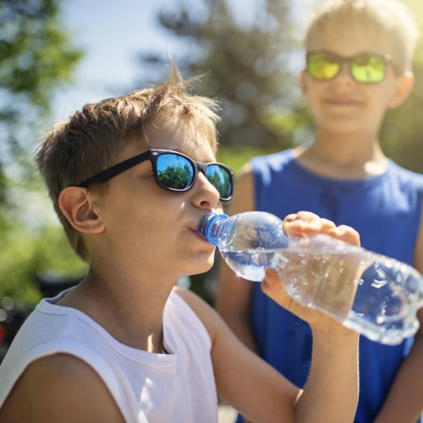 Bub trinkt Wasser aus der Flasche