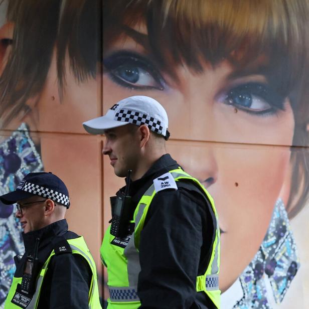 Londoner Polizisten gehen an einem Taylor-Swift-Plakat vorbei