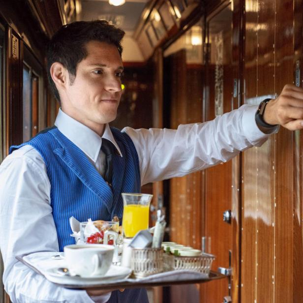 Ein Kellner serviert im Belmond Venice Simplon Orient Express Frühstück