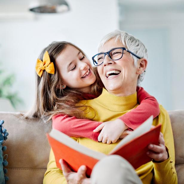Eine Großmutter liest mit ihrem Kind ein Buch.