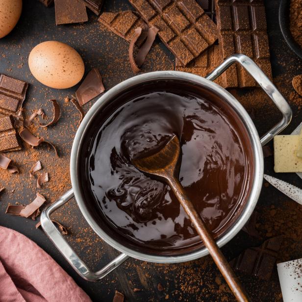 geschmolzene Schokolade im Topf mit Zutaten wie Butter und Eiern