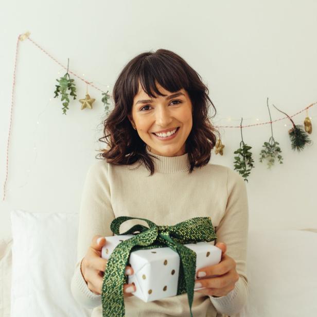 Frau mit einem Weihnachtsgeschenk in der Hand