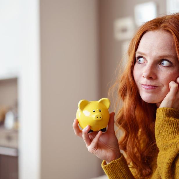 Eine junge Frau mit ihrem Sparschwein