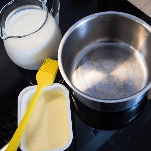 Butter am Rand eines Kochtopfs soll das Überkochen von Milch verhindern