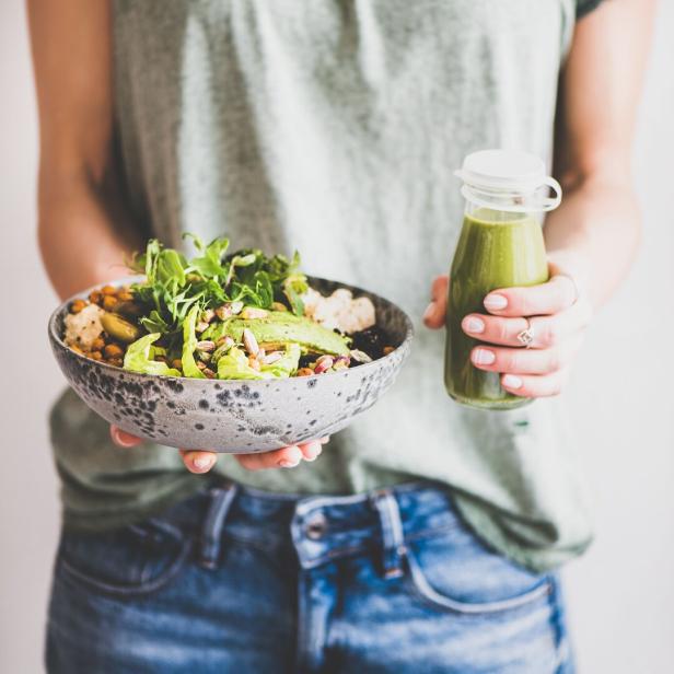 Eine gesunde Bowl mit Hülsenfrüchten, Nüssen und Salat und ein Vitamin-C-Smoothie