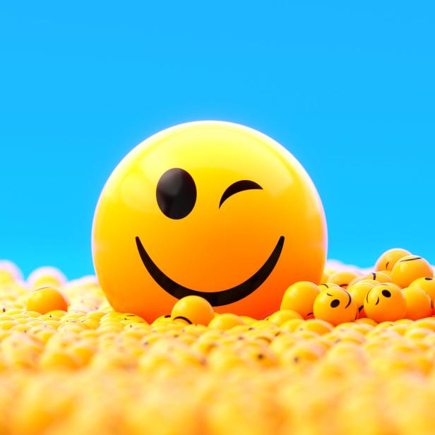 Yellow Spheres Textured With Happy Face Emoji On Blue Background