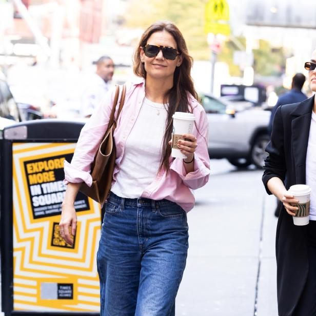 Katie Holmes unterwegs in New York mit einem Kaffeebecher. Sie trägt ein Oberteil und eine passende Jacke, beide in der Trendfarbe Powder Pink.