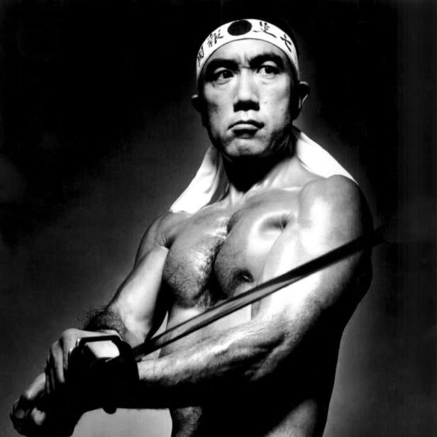 Yukio Mishima  in der Rolle eines idealisierten japanischen Kriegers, der das Stirnband eines Kamikaze trägt und ein Schwert schwingt