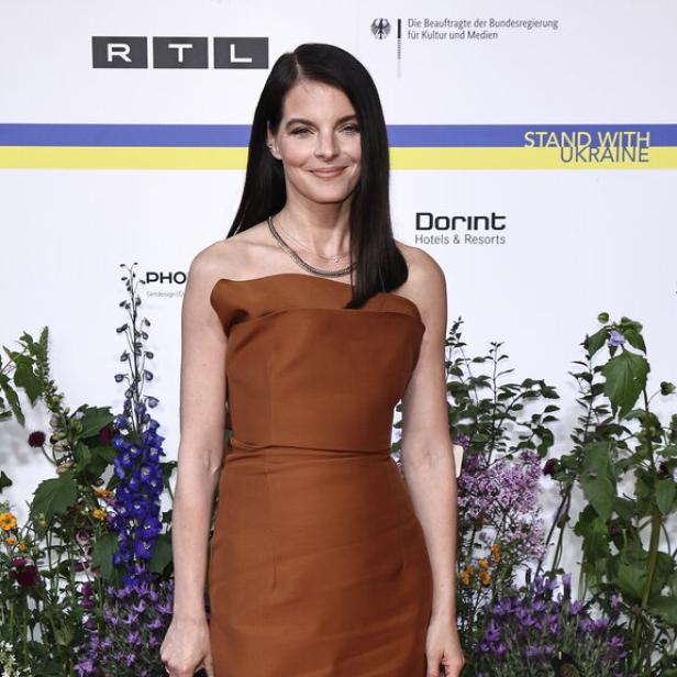 Yvonne Catterfeld bei einer Gala auf dem roten Teppich in einem braunen Kleid