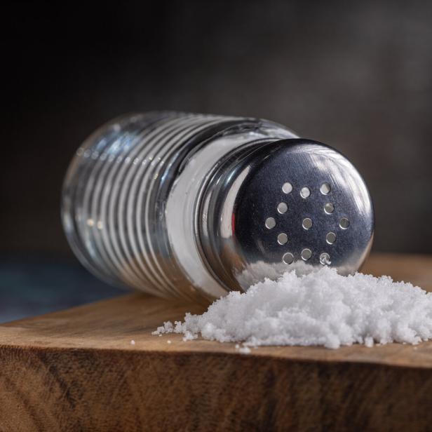 Ein umgefallener Salzstreuer liegt auf einem Tisch.