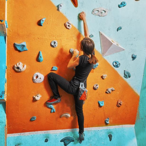 Woman climbing up on practice wall