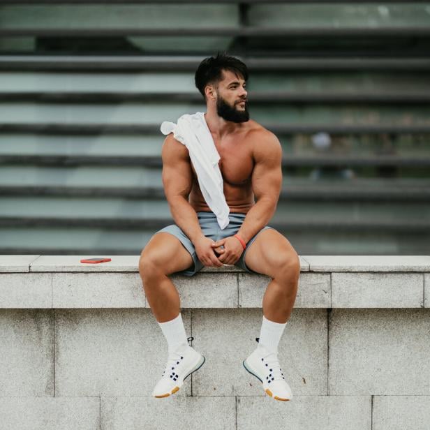 Muscular man relaxing after exercising in the city park Muscular man relaxing after exercising in the city park