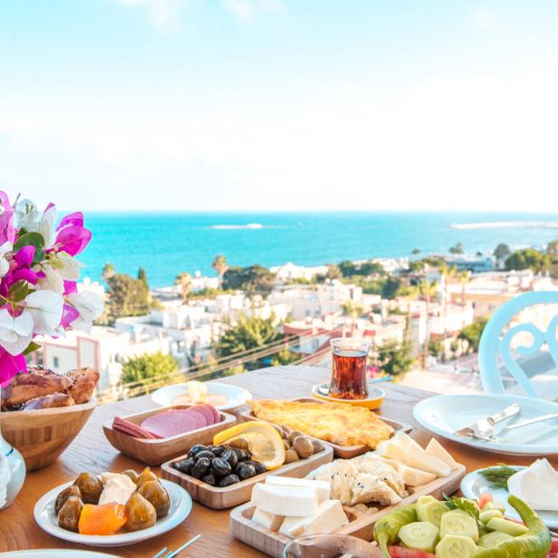 Breakfast on the beach at hotel or resort by the sea in summer season. Holiday and vacation breakfast image. Traditional Turkish or Greek breakfast at bodrum town beach in Turkey or Greece Breakfast on the beach at hotel or resort by the sea in summer season. Holiday and vacation breakfast image. Traditional Turkish or Greek breakfast at bodrum town beach in Turkey or Greece
