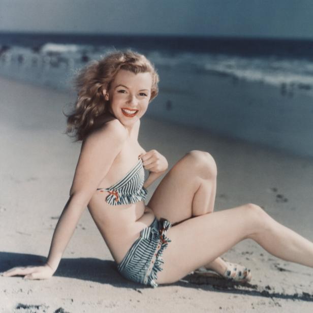 Stilikone Marilyn Monroe posiert im Bikini am Strand.