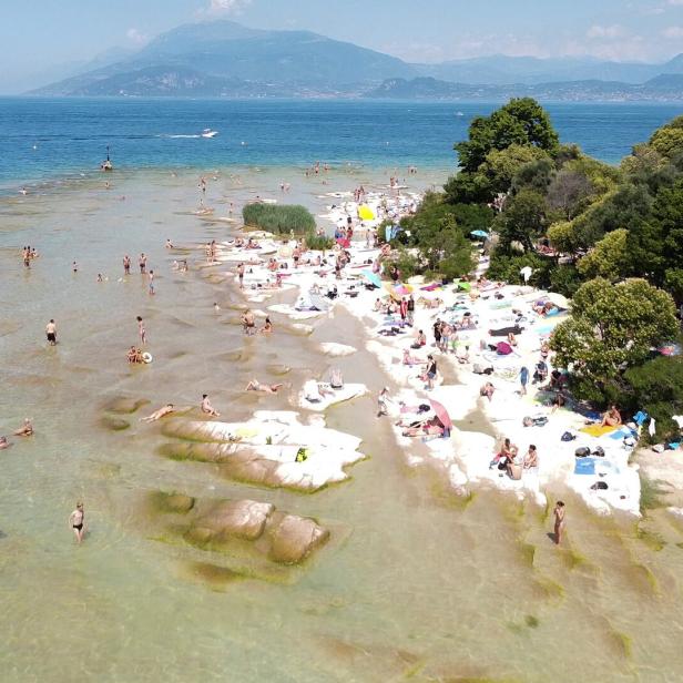 People flock to one of the beaches of Lake Garda, in southern Sirmione Peninsula