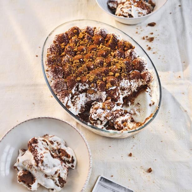 Ein veganes Tiramisu in einer Glasschale, daneben ein Teller und ein Foto.