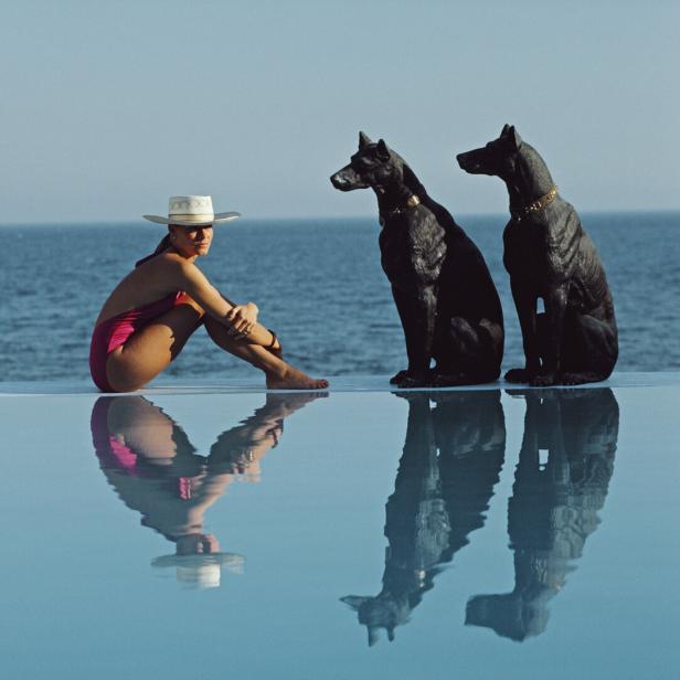 Pantz Pool Eine Frau sitzt am Pool, hinter ihr liegt das weite Meer