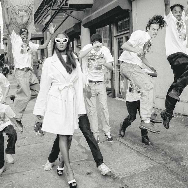 Naomi Campbell auf der Straße, rundherum springen junge Männer und Buben mit Baggy-Pants