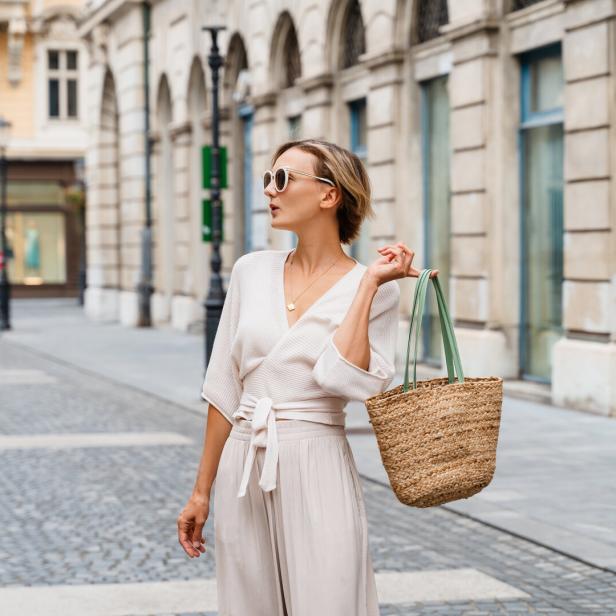 Happy woman wearing stylish outfit exploring of european old town. Travel Vacation Europe.