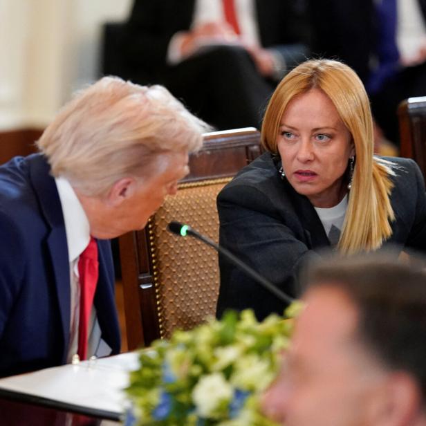Donald Trump mit Giorgia Meloni Donald Trump sitzt neben Giorgia Meloni vor einem Mikro.