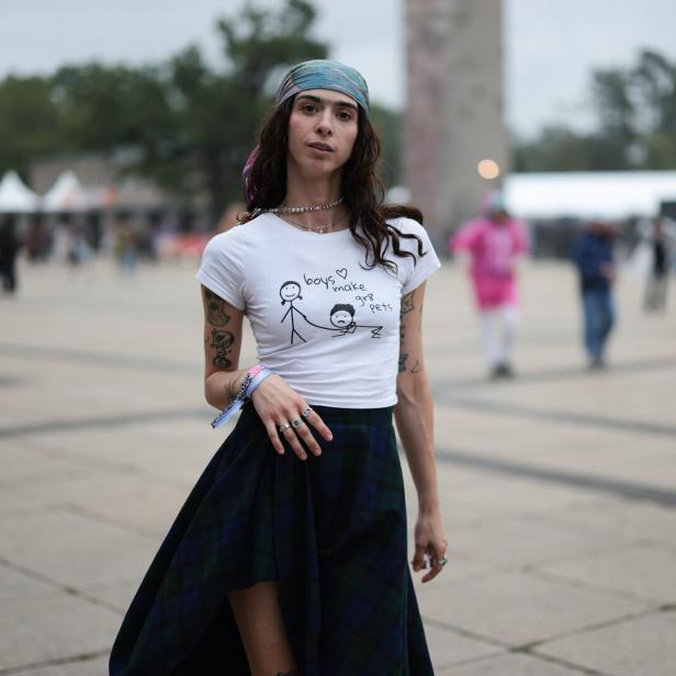 Künstlerin Canel Aylin steht mit einem Seidentuch im Boho-Look, am Hinterkopf verknotet, auf einem Platz in Berlin.